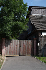 Fototapeta na wymiar gate and house of wood, old house under big tree