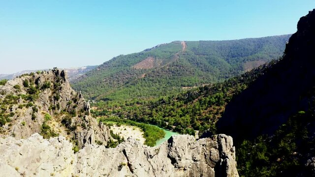 A canyon or gorge is a deep cleft between escarpments or cliffs resulting from weathering and the erosive activity of a river over geologic time scales.