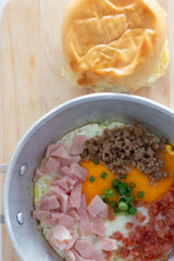 Pan-fried eggs with toppings on a wooden cutting board and bread