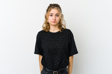 Young caucasian woman on white backrgound shrugs shoulders and open eyes confused.