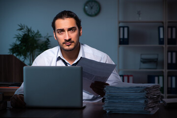 Young male employee working in the office night time