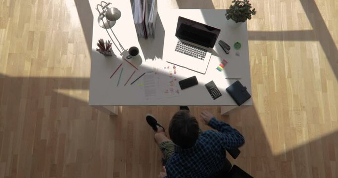 Top view shot of an office worker cleaning up desk and starts to work with floating sun shot in 4k