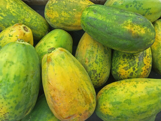 Fresh papayas displayed for sale at a farm market stand