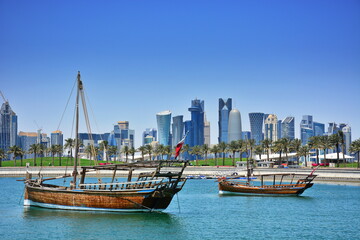 Fototapeta na wymiar Dhow boat harbored against the city skyline of West Bay in Qatar.