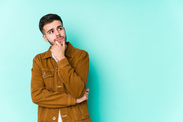 Fototapeta premium Young handsome man looking sideways with doubtful and skeptical expression.