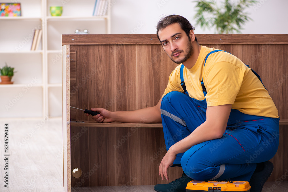 Wall mural Young male carpenter working indoors