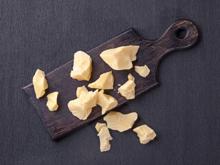 Pieces of natural cocoa butter on black cutting board