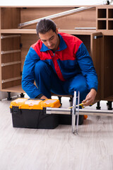 Young handsome male carpenter working indoors