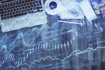 Financial market graph and top view computer on the desktop background. Double exposure. Investment concept.