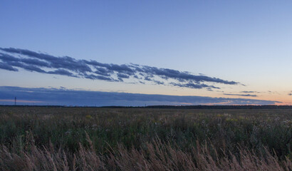 Sunset in Countryside, Moscow region, Russia. Blue clouds, orange sun strip.
