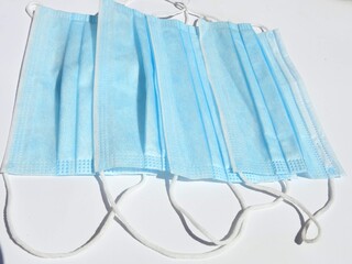 Stack Of Blue Surgical Face Masks Laying On White Background