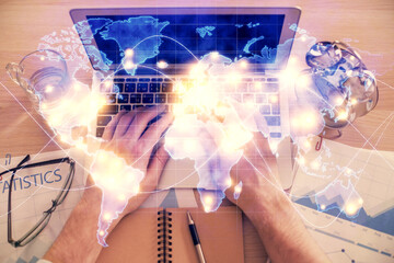 Double exposure of man's hands typing over computer keyboard and business theme hologram drawing. Top view. Financial markets concept.