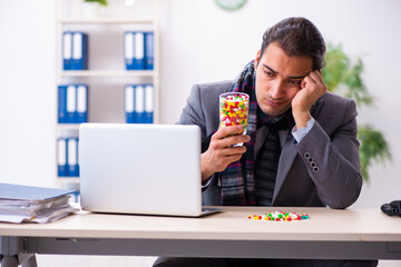 Young male employee suffering at workplace