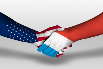 Handshake between luxembourg and united states of america flags painted on hands, illustration with...