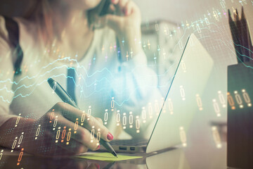 Double exposure of woman hands typing on computer and financial graph hologram drawing. Stock market analysis concept.