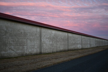 Fototapeta na wymiar Crimson sky against a cold government building. 