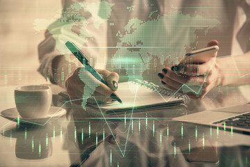 Double exposure of financial graph sketch hologram and woman holding and using a mobile device. Stock exchange concept.