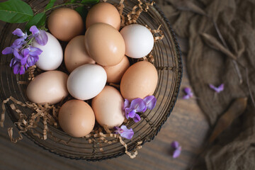 Farm Fresh Brown and White Eggs in a Wire Egg Basket on Wood Table