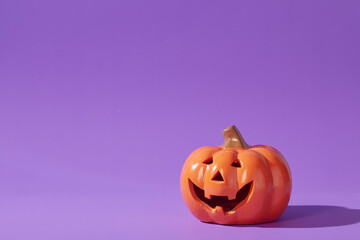 Pumpkin on a violet background, Halloween backdrop.