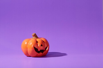 Pumpkin on a violet background, Halloween backdrop.
