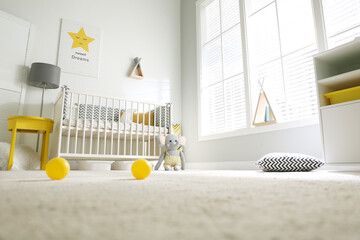 Cute baby room interior with crib and big window, low angle view - Powered by Adobe
