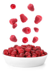 Fresh ripe raspberries falling into bowl on white background
