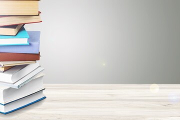 Stack of colored books on wooden desk