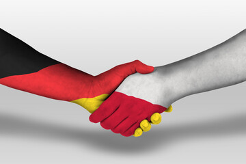 Handshake between poland and germany flags painted on hands, illustration with clipping path.