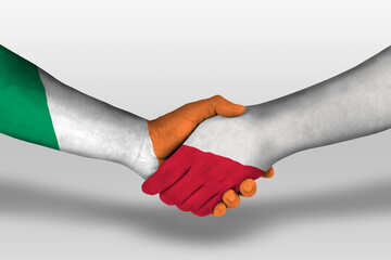 Handshake between poland and ireland flags painted on hands, illustration with clipping path.