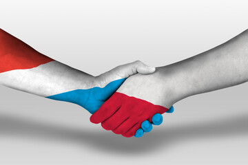 Handshake between poland and luxembourg flags painted on hands, illustration with clipping path.