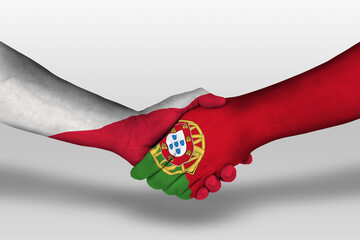 Handshake between portugal and poland flags painted on hands, illustration with clipping path.