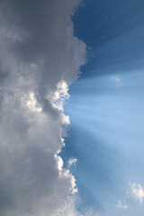 Naklejka na ściany i meble heavenly light rays passing through clouds in blue sky