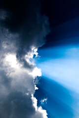  heavenly light rays passing through clouds in blue sky