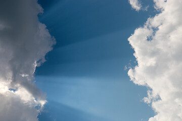  heavenly light rays passing through clouds in blue sky