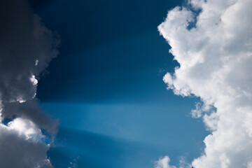  heavenly light rays passing through clouds in blue sky