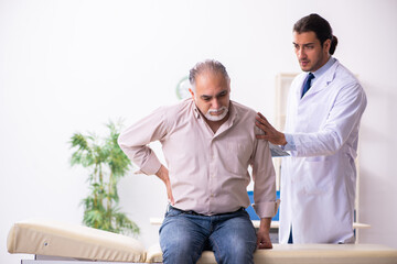 Obraz premium Old patient visiting young male doctor