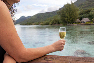 A woman drinks a glass of cold champagne on a tropical island vacation