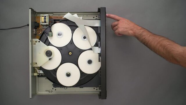 Hand Replaces Blank CD in Open Topped Five Disc Player, Top Down
