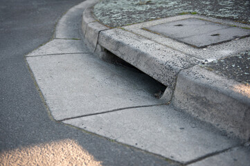 Gutter of a stormwater drainage system in perspective on the side of an road with markings. Australia. Melbourne. 