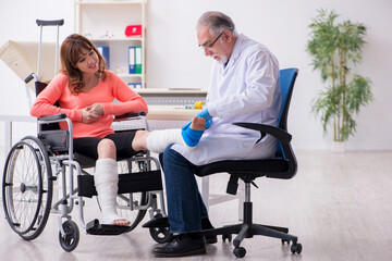 Young leg injured woman visiting old doctor traumatologist