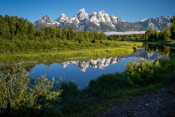  Schwabachers Landing in the early morning in Grand Teton National Park, with mountain reflections on the water creek
