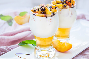 Healthy strawberry, peach and walnut parfait in a glass on a white background