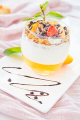 Healthy strawberry, peach and walnut parfait in a glass on a white background