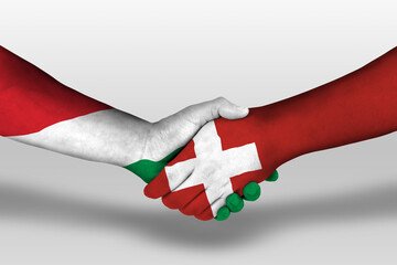 Handshake between switzerland and hungary flags painted on hands, illustration with clipping path.
