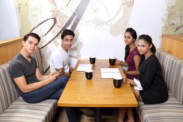 group of Asian young man woman friend student colleagues talk mingle study discuss coffee shop look at camera