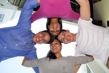 group of Asian young man woman friend student colleagues looking down heads together in circle