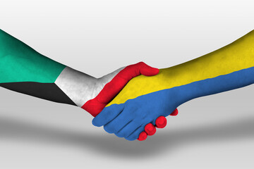 Handshake between ukraine and kuwait flags painted on hands, illustration with clipping path.