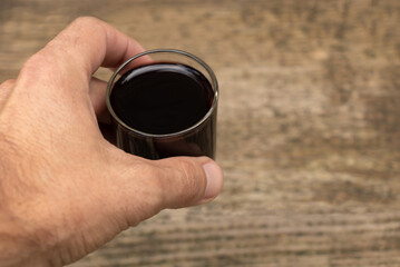 A glass of red wine in a man's hand