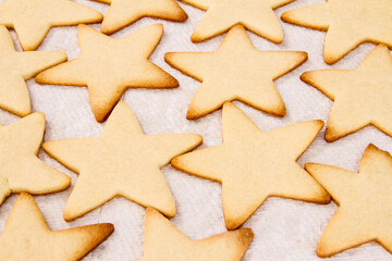 Baked sugar cookies cooling on a paper towel; top down view of freshly baked warm sugar cookies
