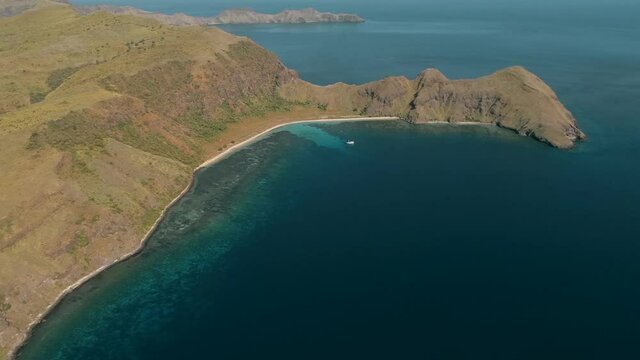 Wild islands of Indonesia. Flores. tropical paradise. Labuan Baggio. drone shooting. Wild beaches, blue logons, coral reefs, green hills. aerial view. boat trip safari. 